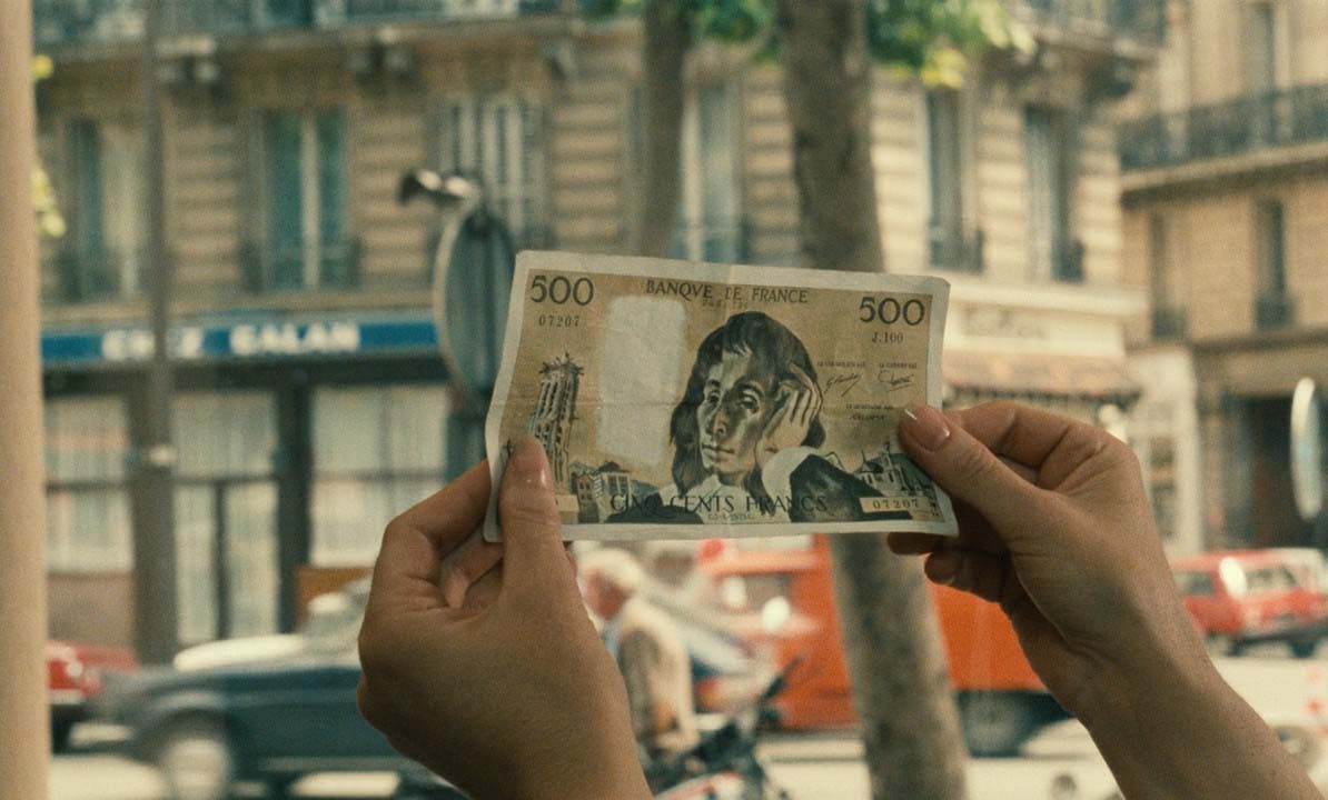 Person holding up French note.